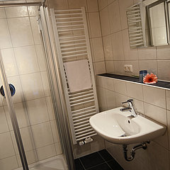 Das Badezimmer des Hotelzimmer mit Waschbecken und Dusche.