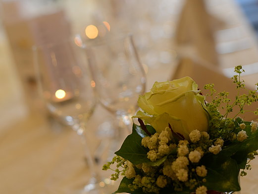 Eine Nahaufnahme eines gedeckten Tisches mit Gläsern und Blumendekoration.