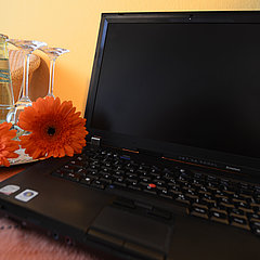  A laptop on the hotel room table with beverage arrangement.